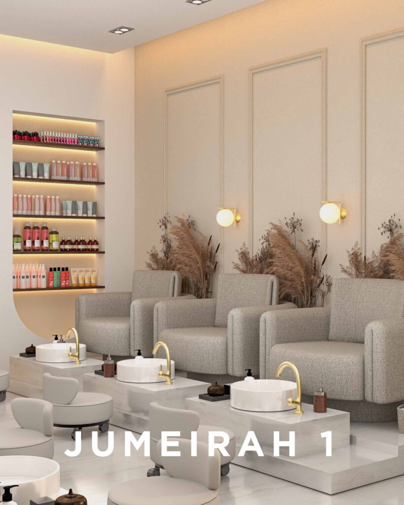 Plush pedicure spa in Jumeirah 1 with grey armchairs, white basins, gold faucets, and a shelf of beauty products—interior by The House Of Kalaa