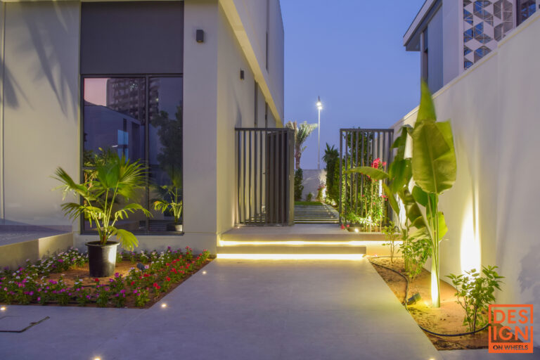 Modern villa side backyard in Dubai with soft night step lighting, natural greenery, and minimalist landscape design.